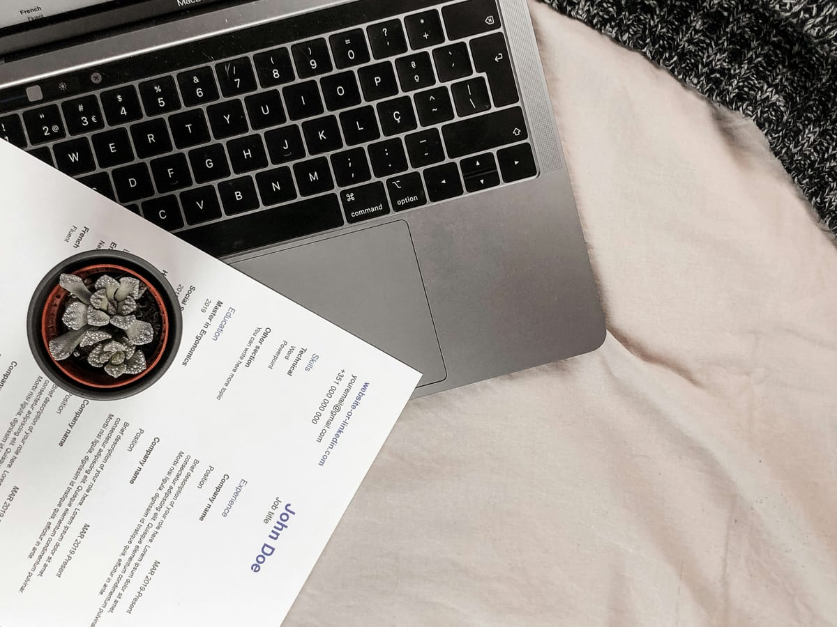 CV posé sur un bureau à côté d'un ordinateur