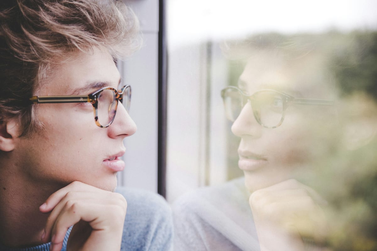 Personne en pleine réflexion, regard vers la fenêtre